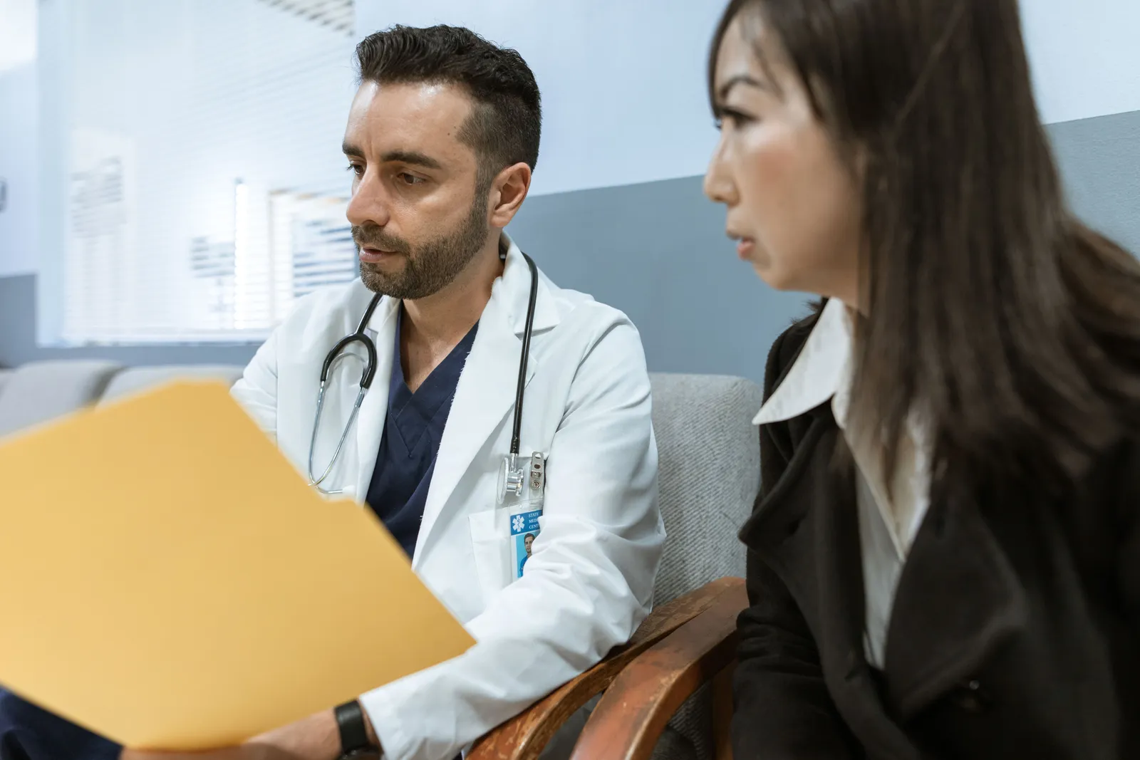 Doctor talking with a patient across a desk in a clinic office