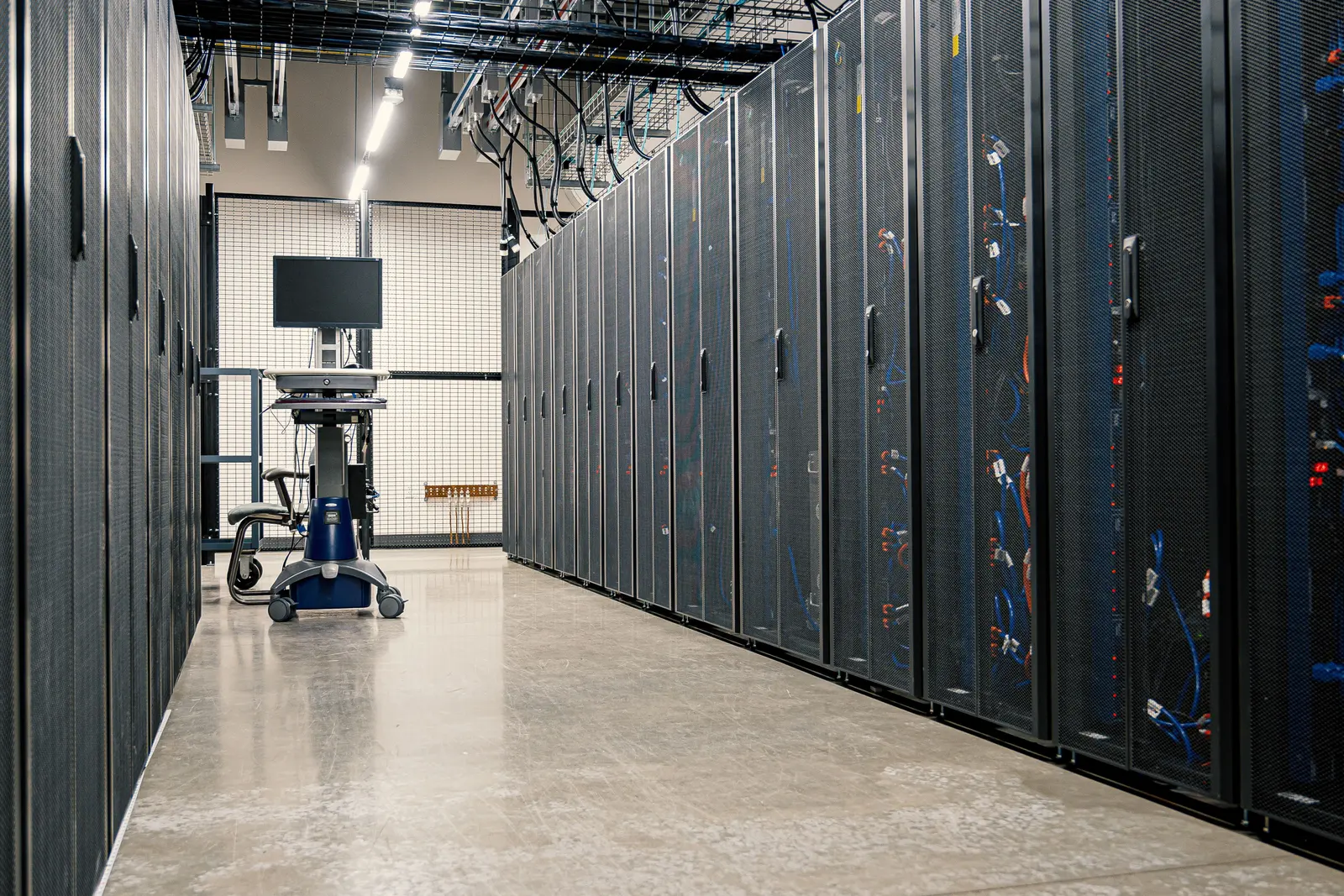 Steel cabinets of servers and network cables in an equipment room
