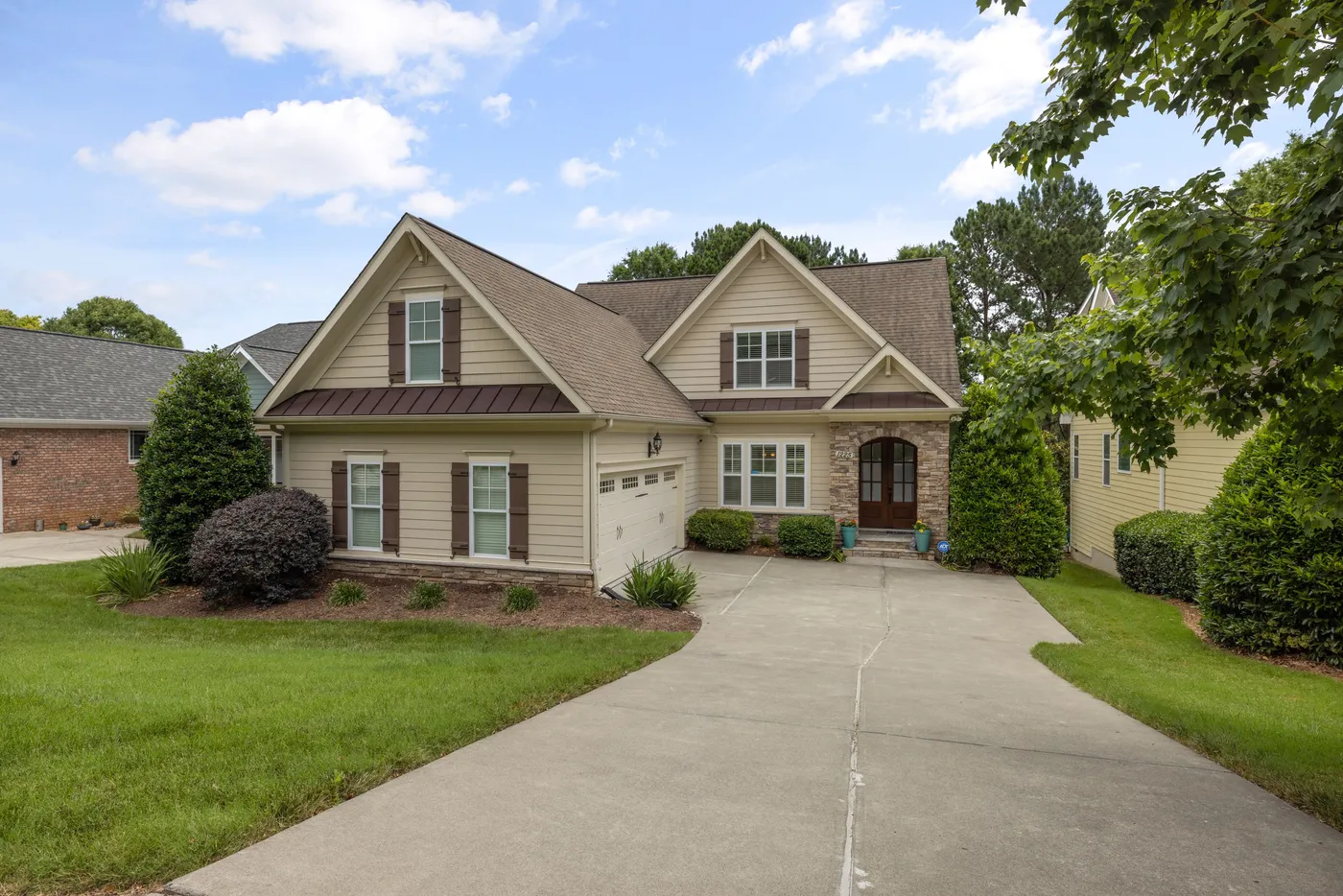 Suburban family house with a driveway and mowed front lawn on a clear day