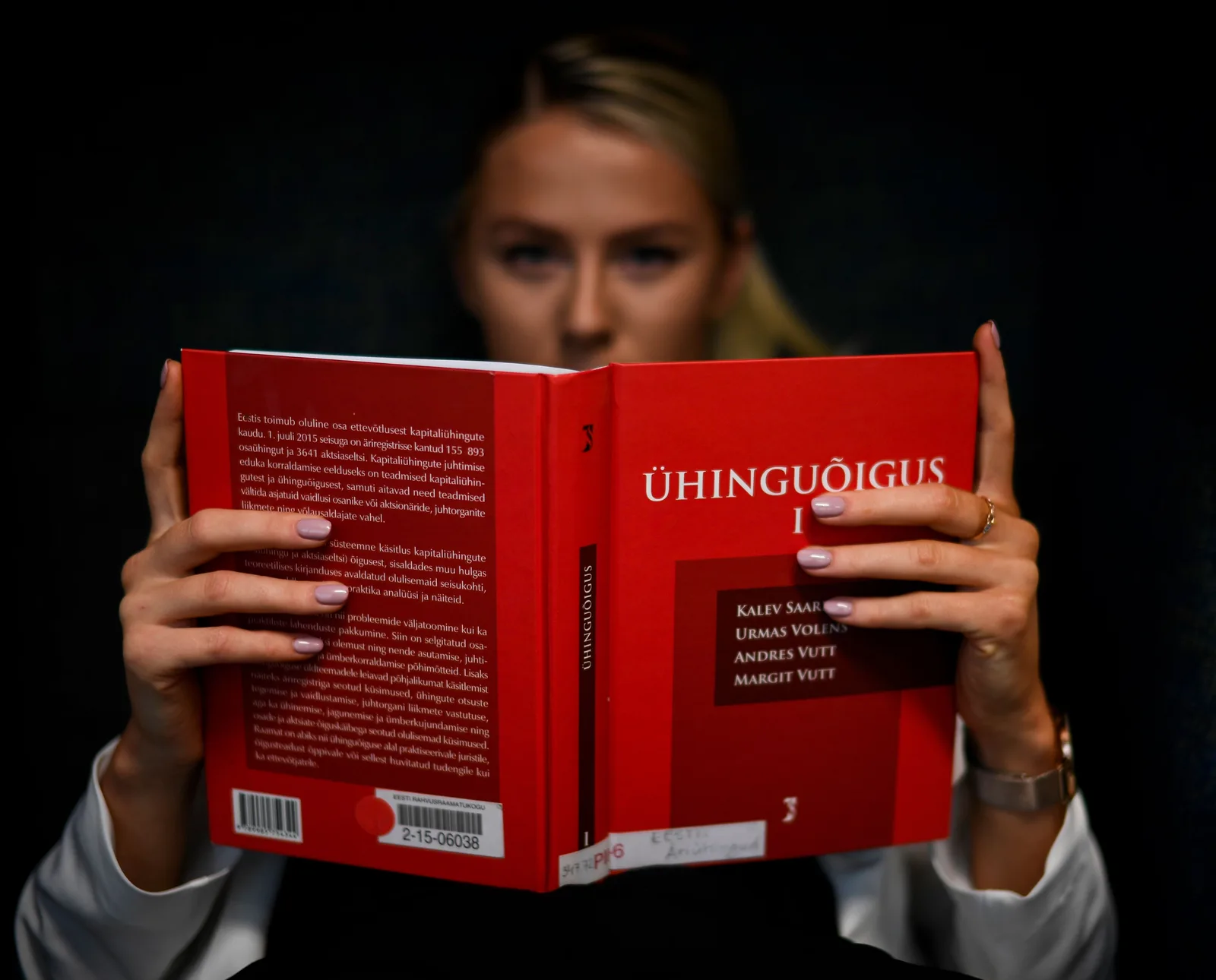 A law student reading a legal textbook at a table indoors
