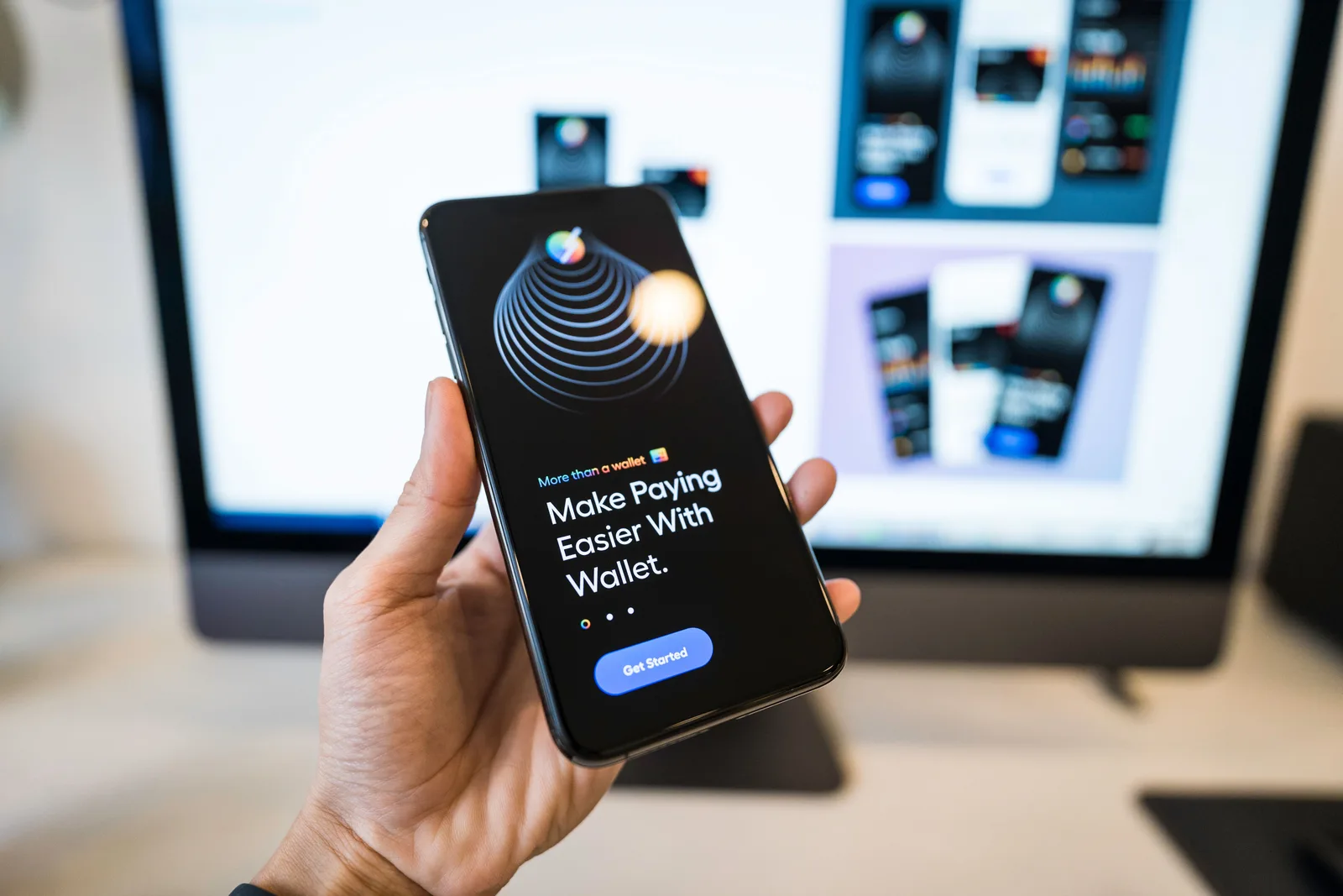 Hand holding a smartphone showing a digital wallet app screen