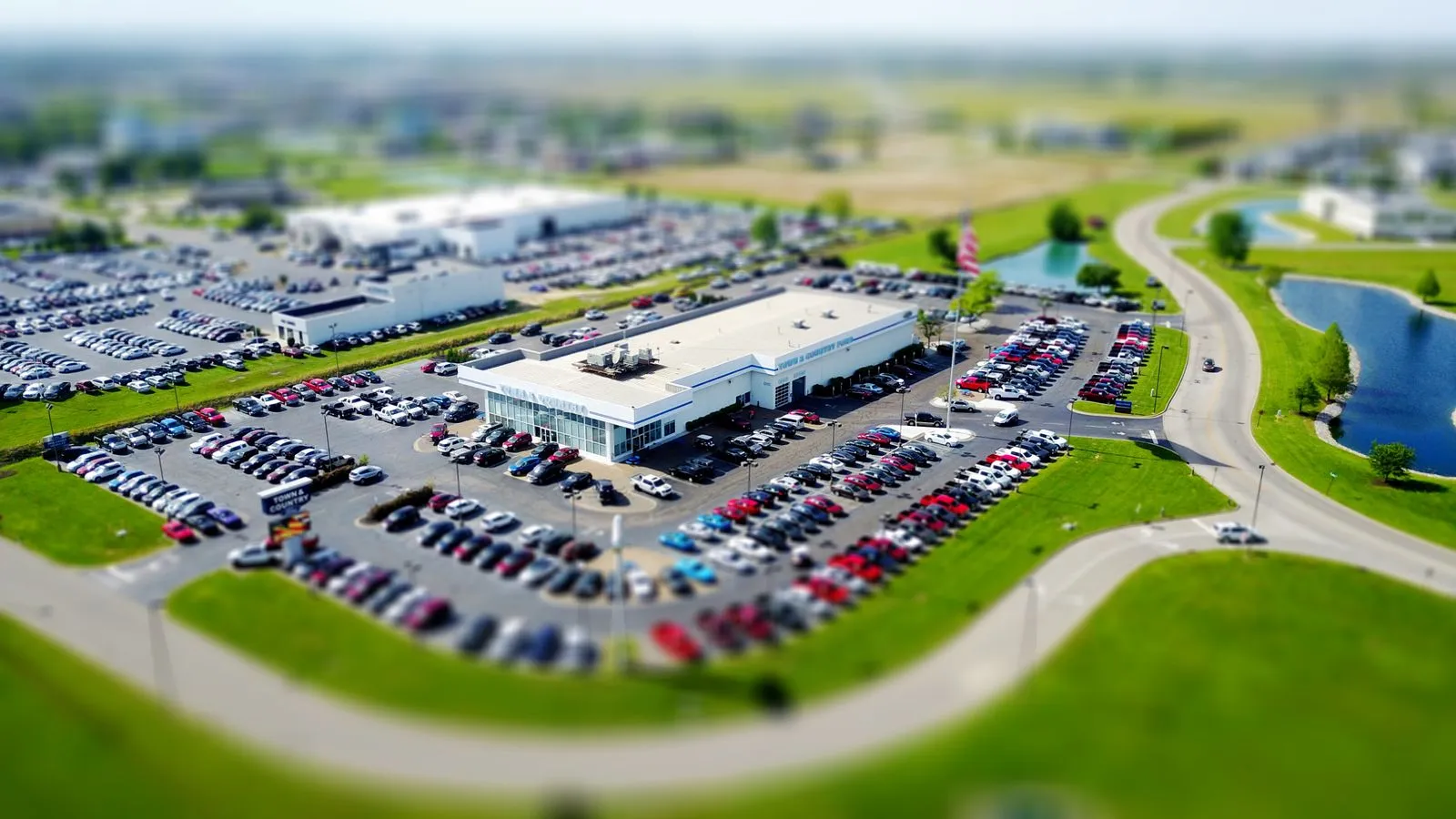 Aerial view of a car dealership lot filled with parked vehicles