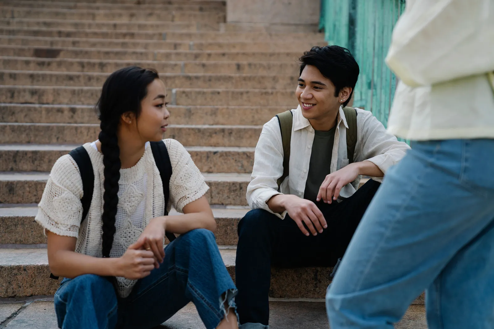 Two students sitting and talking on concrete campus steps