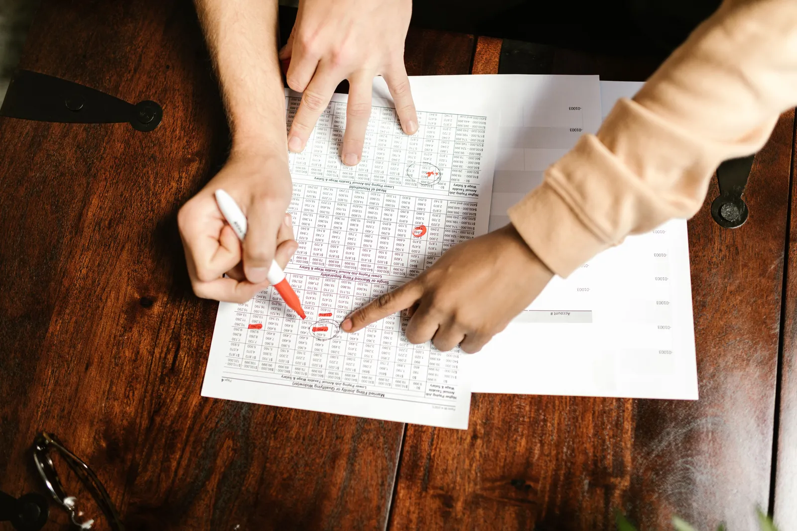 Two people reviewing a printed document together at a table